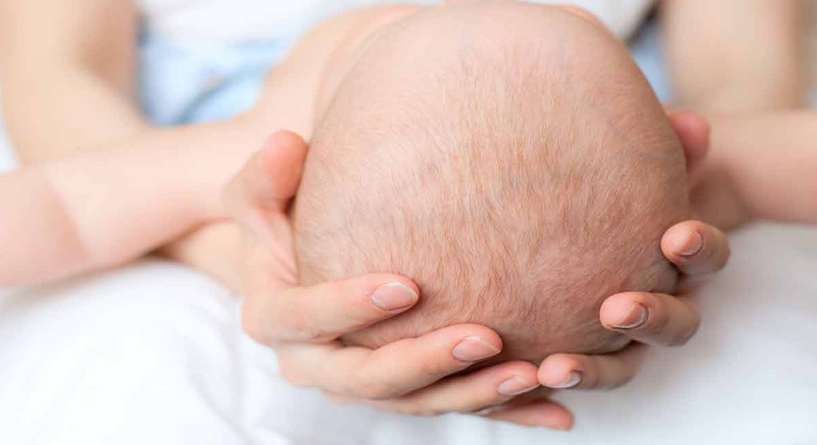 لمس رأس الطفل حديث الولادة