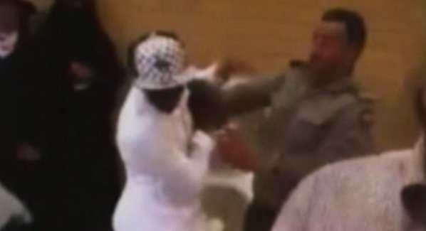 موظف جوازات سعودي يرفع حزامه على مراجعين أجانب