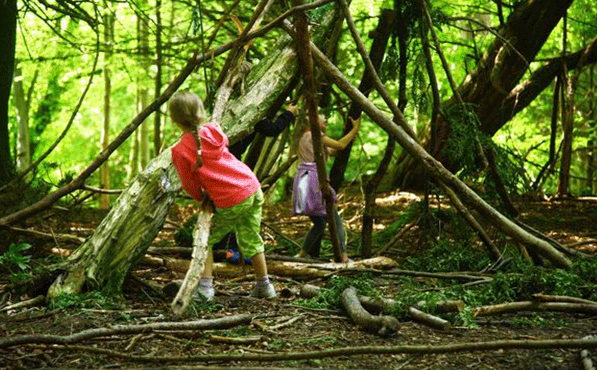 اطفال يبنون خيمة من الأخشاب