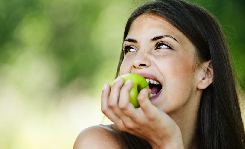 امرأة تأكل التفاح