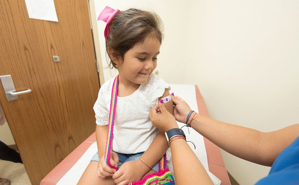 طفلة في سن المدرسة تحصل على اللقاح