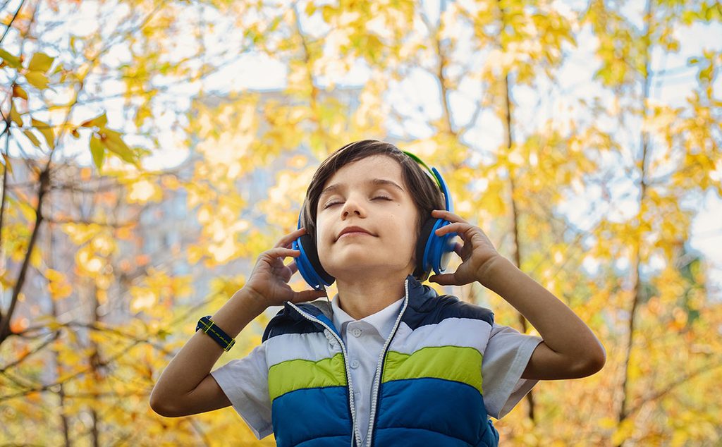 طفل يستمع الى الموسيقى في الطبيعة
