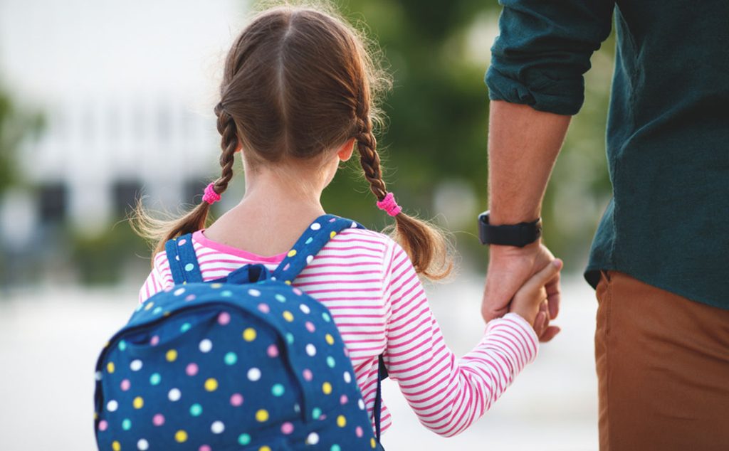 طفلة ذاهبة إلى المدرسة مع والدها