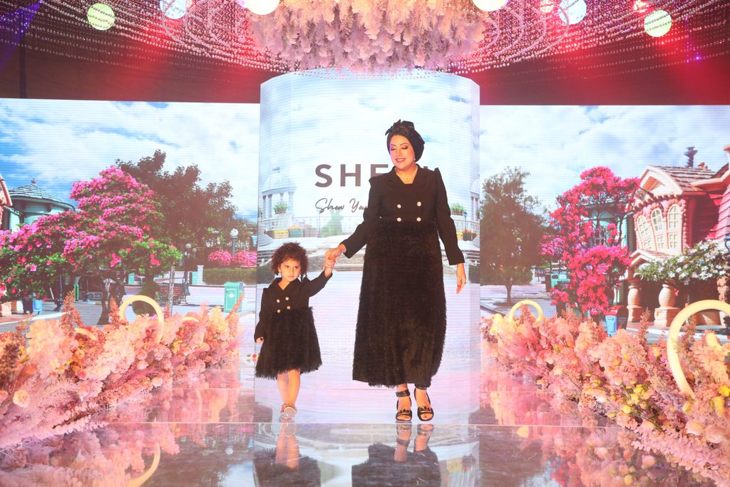 إمرأة ترافق طفلك صغيرة خلال عرض أزياء من تنظيم SHEIN