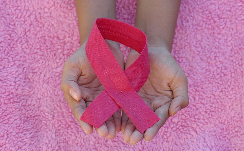 إمراة تحمل شارة حملة سرطان الثدي