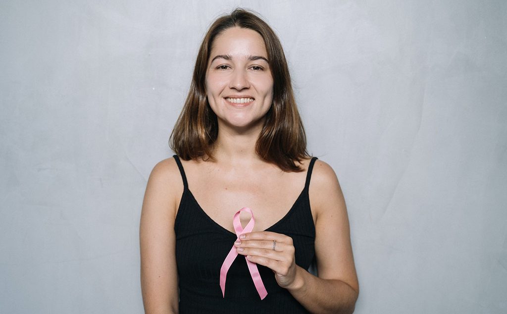 إمرأة تحمل شارة حملات مكافحة سرطان الثدي