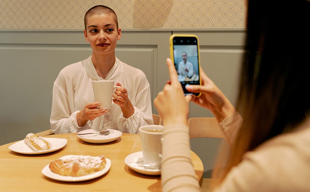 إمرأة مصابة بالسرطان تشرب القهوة مع صديقتها