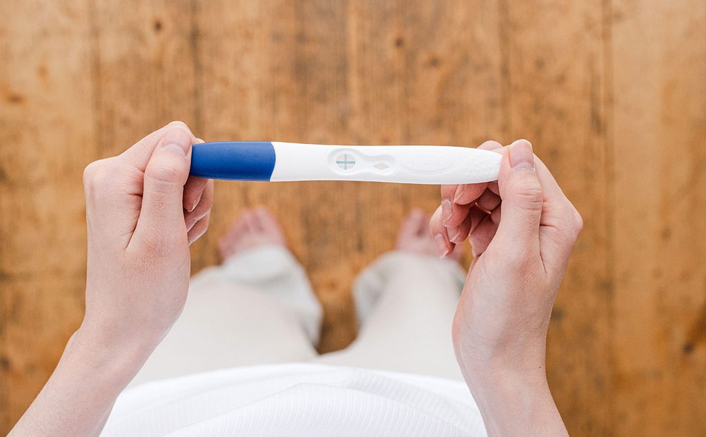 إمرأة تحمل اختبار الحمل المنزلي الإيجابي