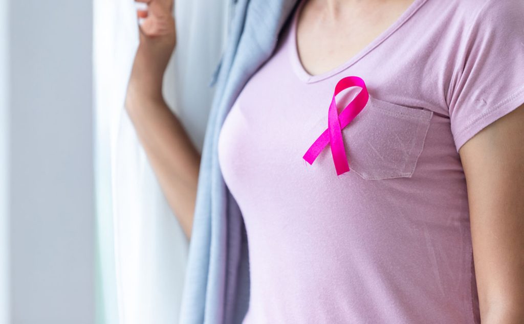 إمرأة تضع شارة حملات مكافحة سرطان الثدي على صدرها