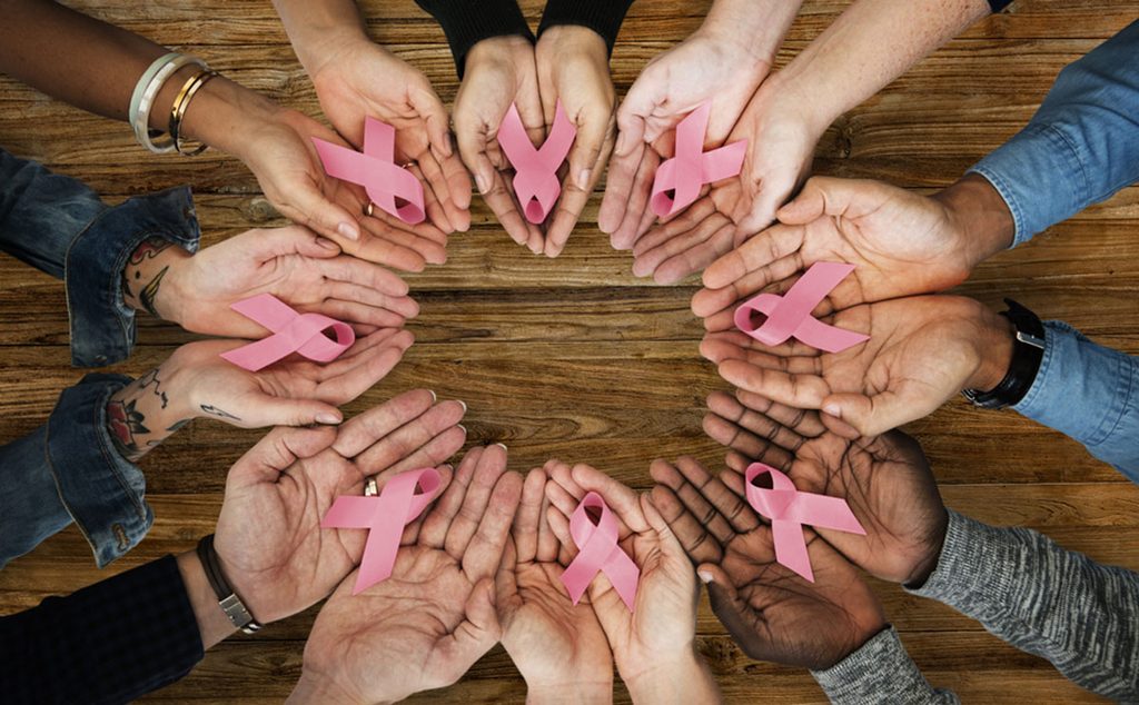 نساء ورجال يحملون شارة سرطان الثدي