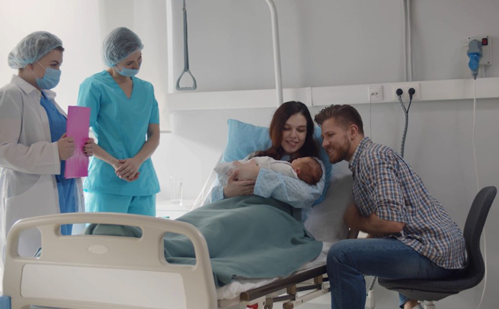 عائلة سعيدة بمولودها الجديد مع الممرضات في المستشفى