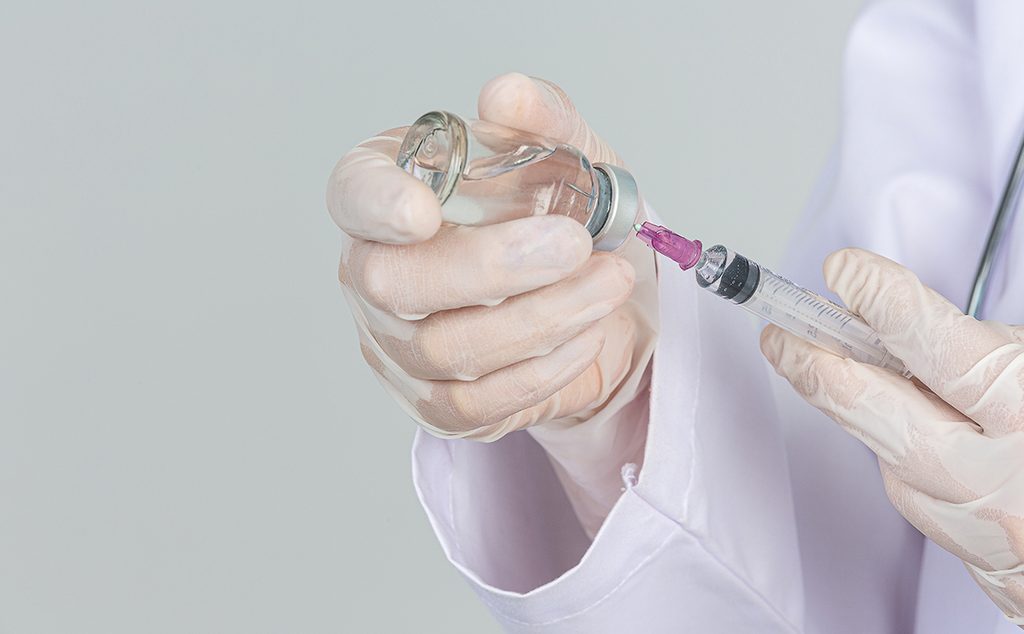 طبيب يسحب اللقاح في الإبرة