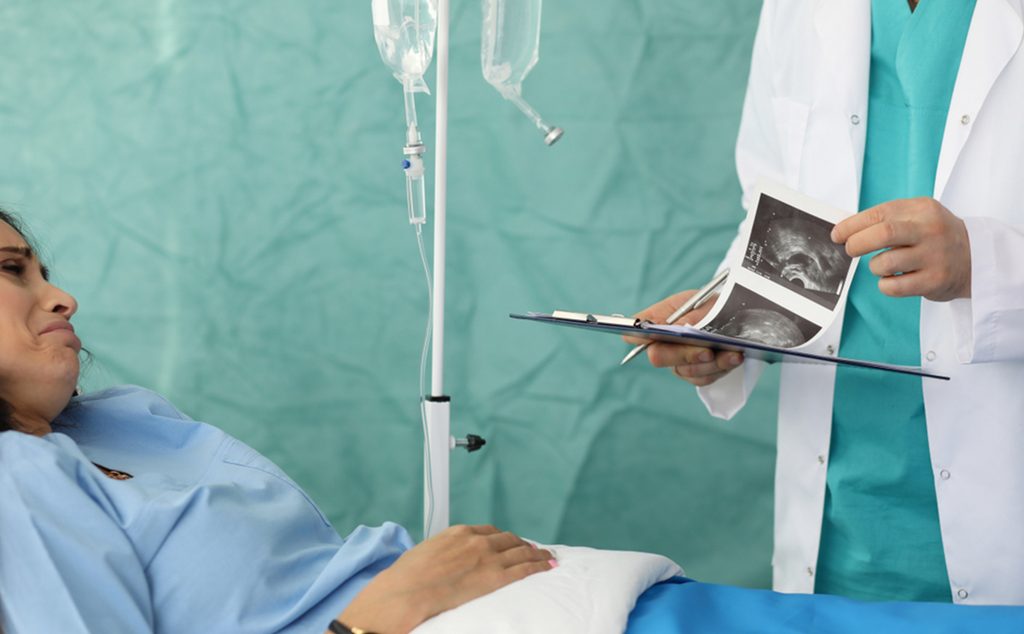 حامل في المستشفى مع طبيبها الذي يحمل صور السونار