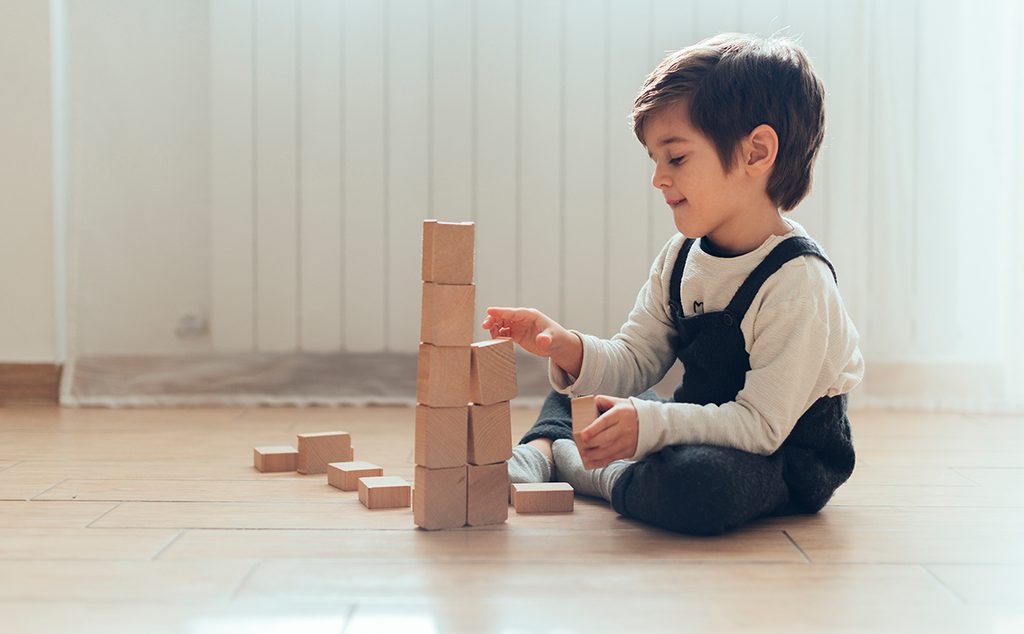 طفل يعلب بالألعاب الخشبية بمفرده