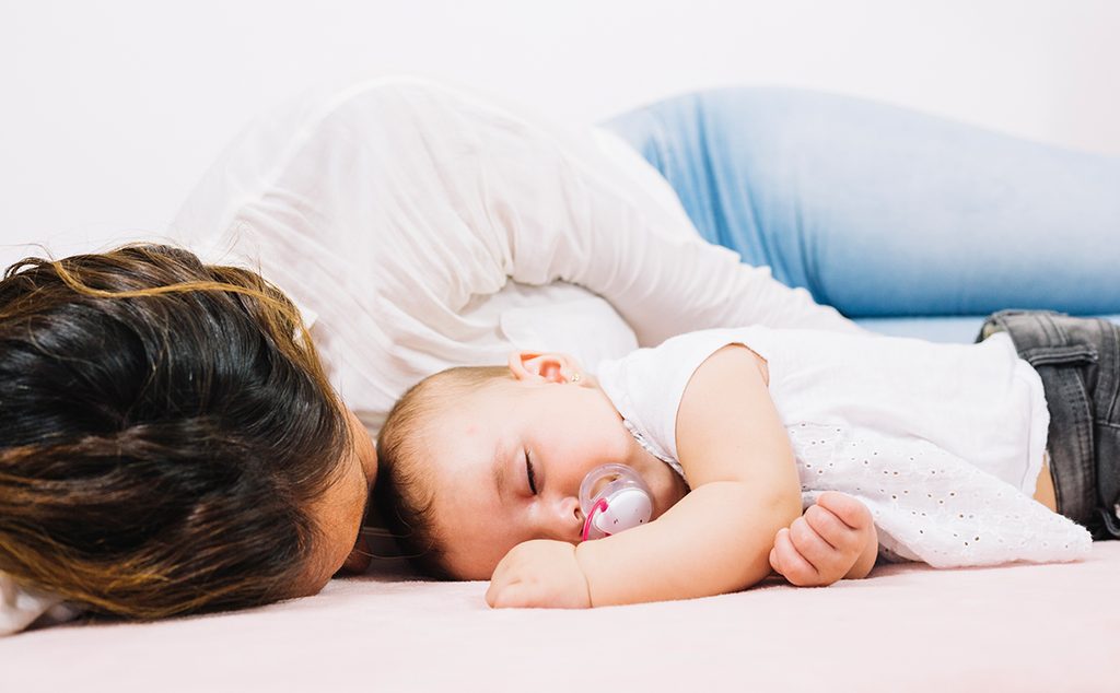 أم تنام بجانب طفلها الرضيع