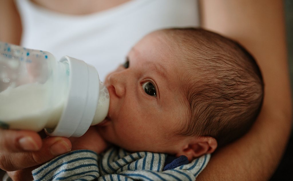 طفل رضيع يشرب الحليب الصناعي بالزجاجة