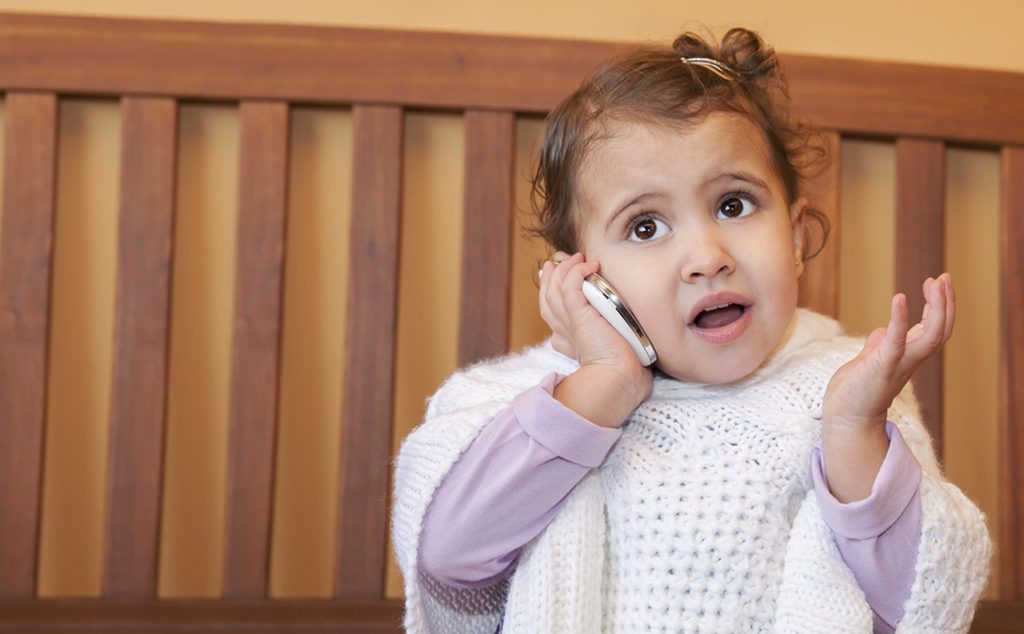 طفلة صغيرة تتكلّم على الهاتف