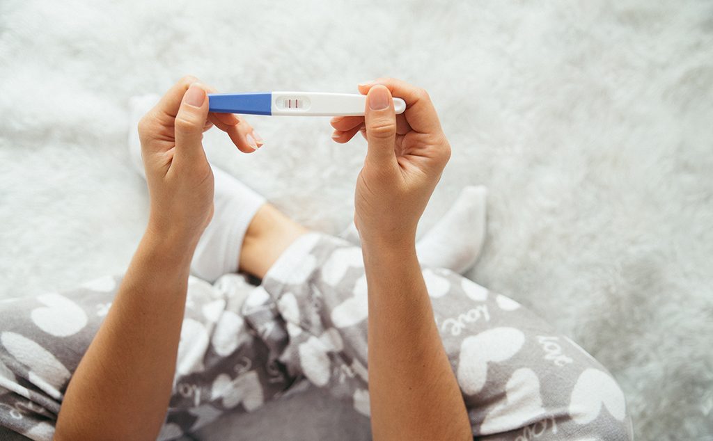 إمرأة تحمل اختبار الحمل المنزلي بنتيجة إيجابية