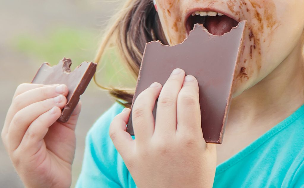 فتاة صغيرة تأكل الشوكولاته بشهية