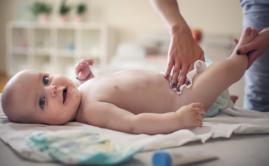 أم تغير حفاضات طفلها