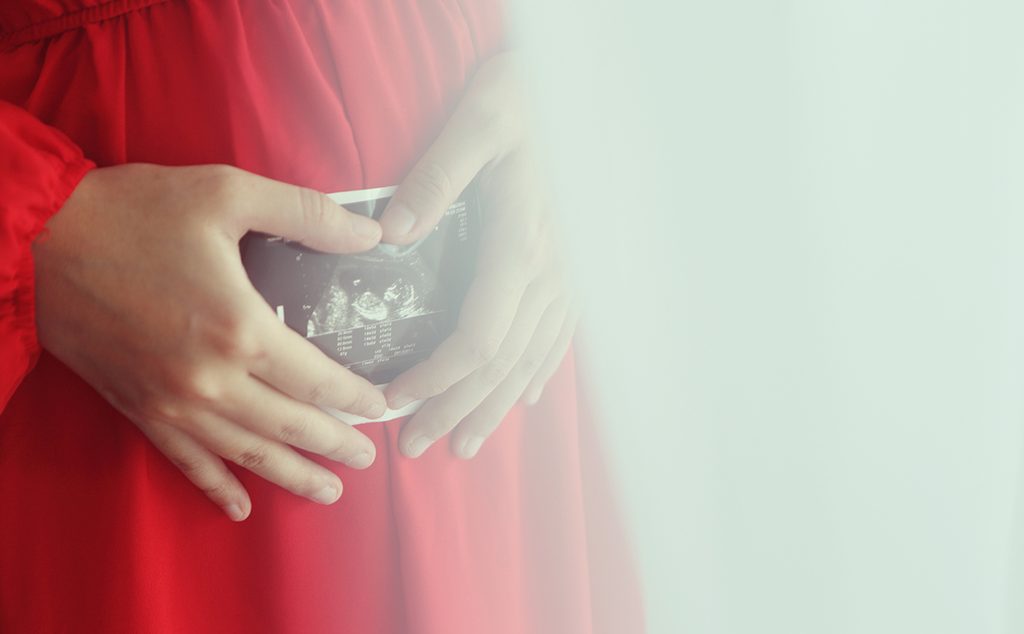 إمرأة في بداية الحمل تحمل نتيجة السونار