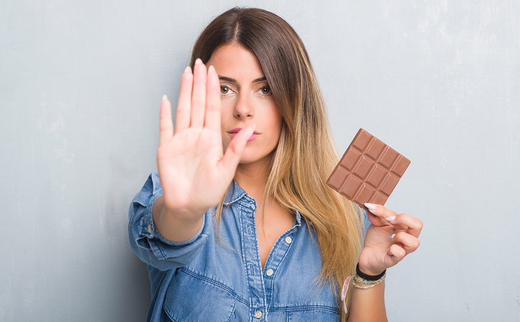 إمرأة تحاول منع نفسها من تناول الشوكولاته