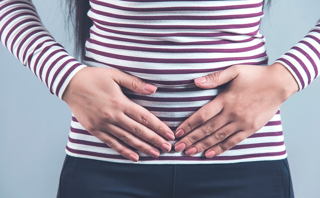 إمرأة تضع يديها على بطنها