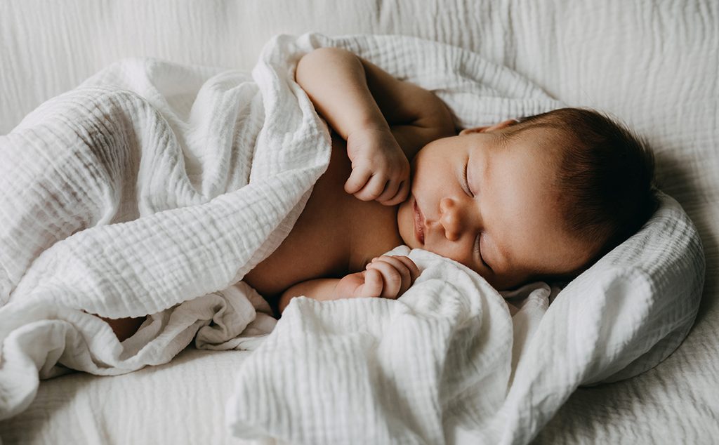 طفل رضيع نائم في بطانيته