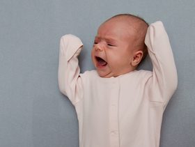 سبب بكاء الرضيع عند وضعه في السرير
