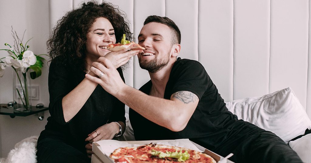 زوجان يتناولان البيتزا