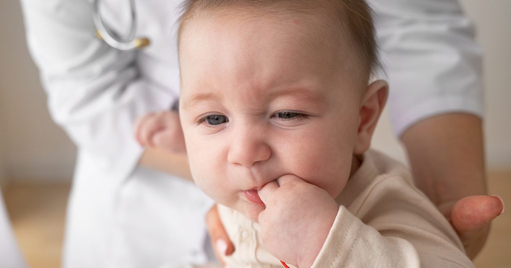 طفل يبكي ويضع يده في فمه