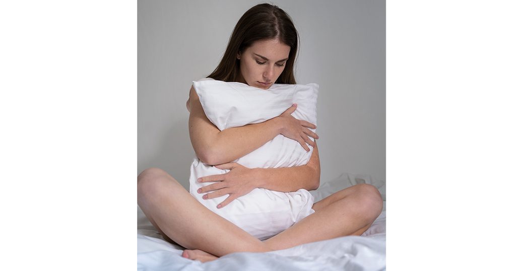 صورة لإمرأة تعانق وسادتها