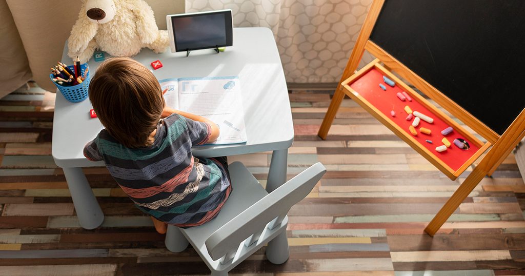 طفل يلعب في غرفته على طاولة بحجمه