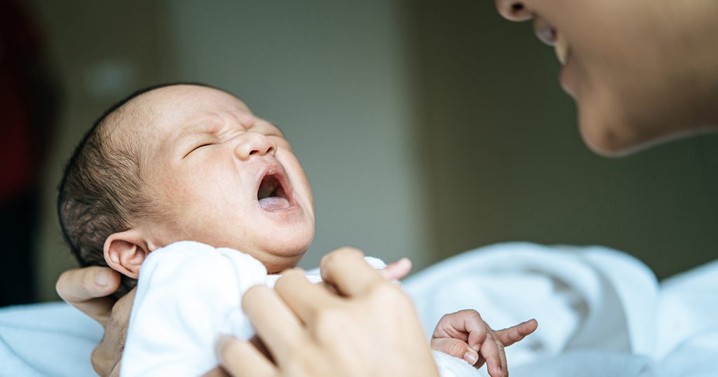 أمّ تحاول تهدئة طفلها الرضيع