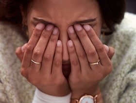 سيدة تغطي وجهها باكيًة