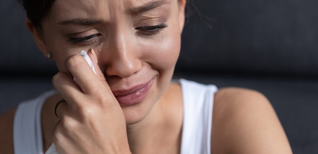 سيدة تمسح دموعها