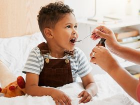 أم تعطي الدواء لإبنها