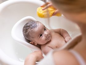 أم تحمم طفلها في الحوض