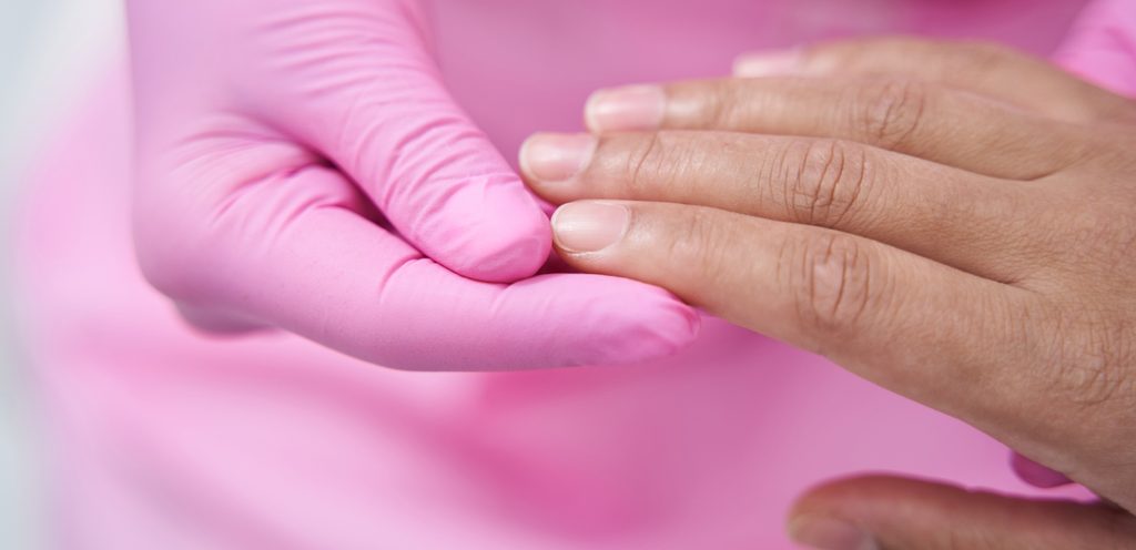 طبيب يتفحص أظافر المريض