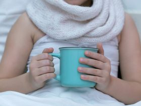 طفلة مريضة تشرب شاي ساخن