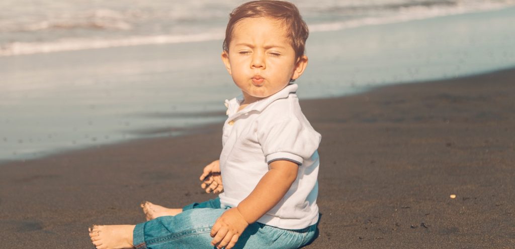 طفل على الرمال تحت الشمس