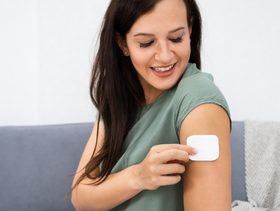 حامل تضع لاصقة منع الحمل على ذراعها