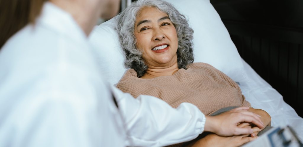 امرأة كبيرة تزور الطبيبة وتضع يدها على بطنها