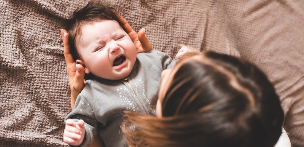 أمّ تحاول أن تُهدئ طفلها الذي يبكي