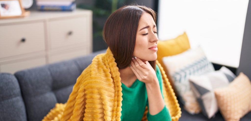 امرأة تشعر بالبرد وتُعاني من آلام الحلق