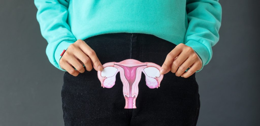 امرأة تُمسك صورة تُجسّد الجهاز التناسلي الأنثوي