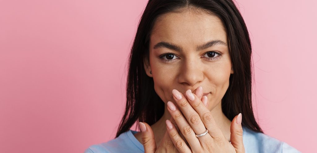امرأة تشعر بالخجل وتضع يديها أمام فمها