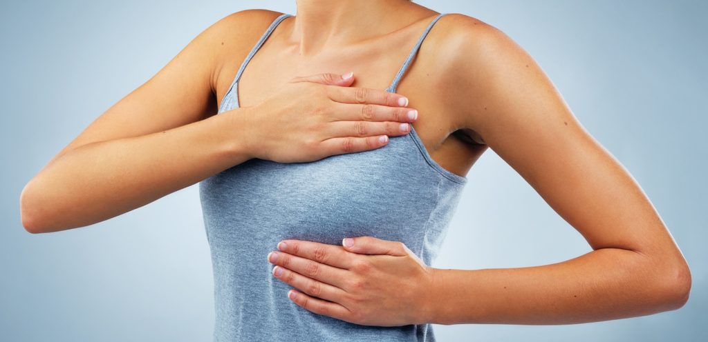 امرأة تضع يديها حول ثديها