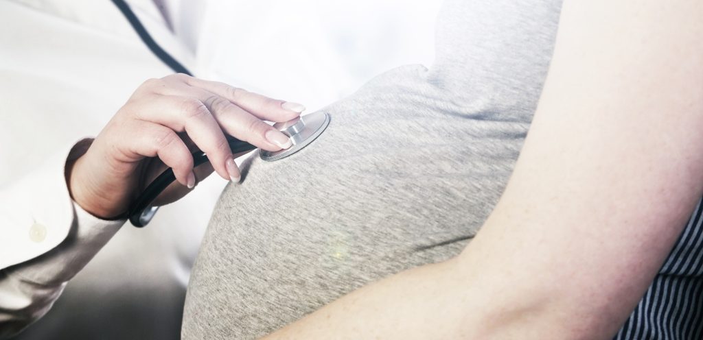 طبيبة تفحص بطن امرأة حامل