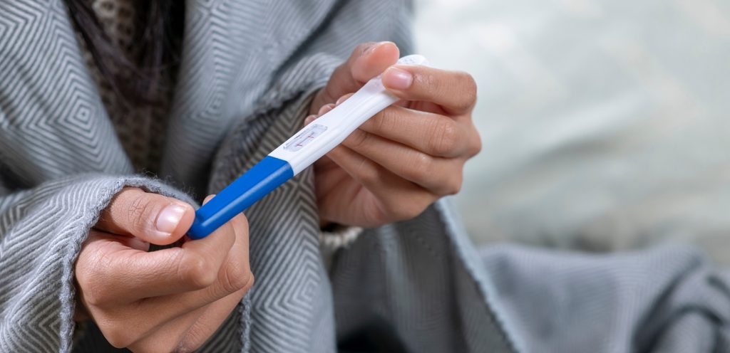 امرأة تمسك باختبار الحمل